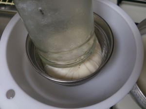 201210-making-soymilk-15 空き瓶の底で包んだガーゼを押し、絞ります。